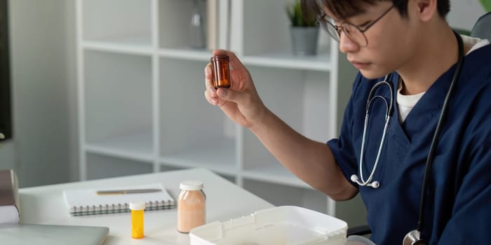 A dedicated medical student carefully inspects medication bottles, emphasizing the significance of pharmaceutical education.
