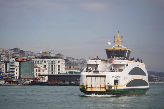 A ferry makes its way through the water, approaching a vibrant shore.