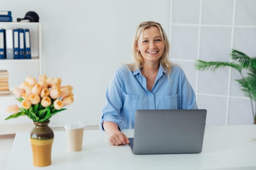 woman blonde working with laptop online in office
