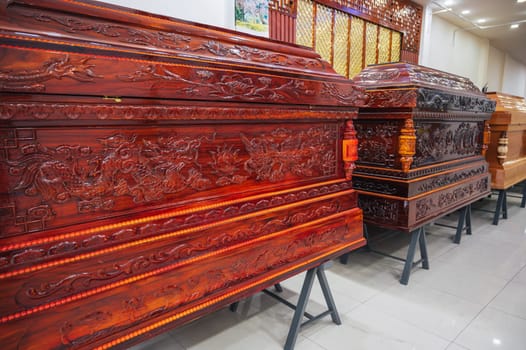 wooden coffins with a traditional Asian ornament pattern in a store in a funeral home in Asia in Vietnam