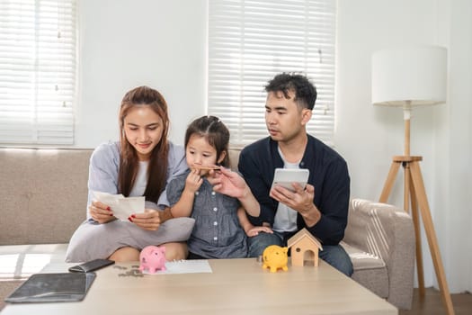 A family discusses financial documents together, promoting budgeting and savings education with their child.