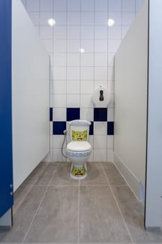 This is a modern toilet stall showcasing a vibrant, artistic toilet design complemented by sleek, clean lines
