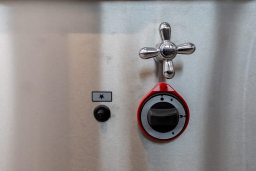 Closeup of a sophisticated mechanical control with a valve and indicator on a shiny metallic surface