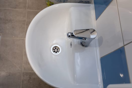 This stylish bathroom sink beautifully showcases its sleek design along with a modern chrome faucet feature