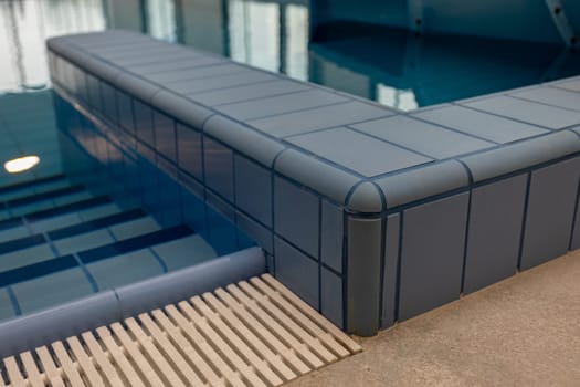 This indoor pool features a modern design with a sleek tiled edge and soothing blue tones for a calming vibe