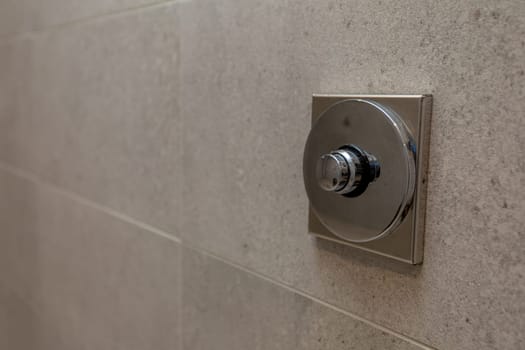 A closeup view of a sleek and stylish shower control valve that has been expertly installed on a contemporary wall