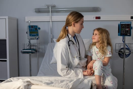 In a clean hospital setting, a nurse interacts warmly and compassionately with a young patient, providing care