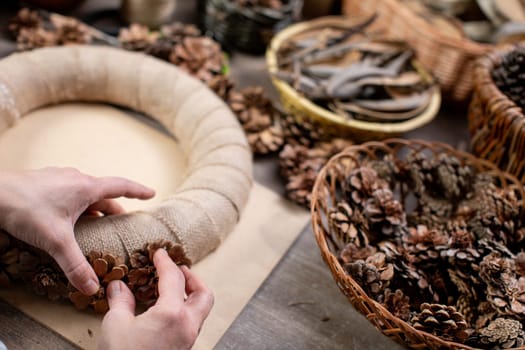 Creating a stunningly beautiful wreath made from natural materials such as pinecones, twine, and more