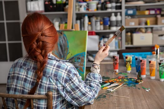 A talented artist passionately painting, surrounded by a vibrant array of colors and various art supplies