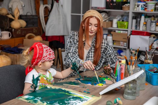 A mother and her child joyfully engaging in a fun painting session, encouraging creativity and strengthening their bond