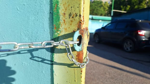 Rusty chain securing a gate on a bright sunny day.