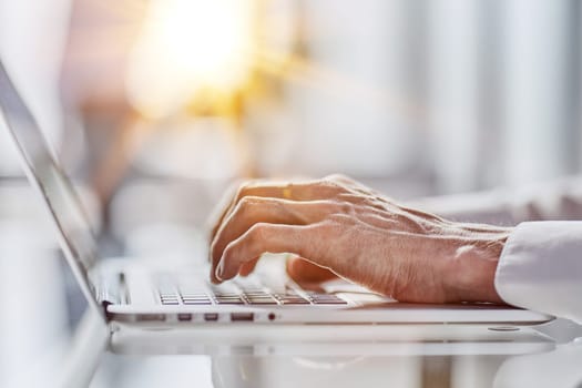 man's hands typing on laptop. Brown male hands pressing buttons on laptop computers.