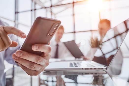 Serious office worker using mobile phone, close-up