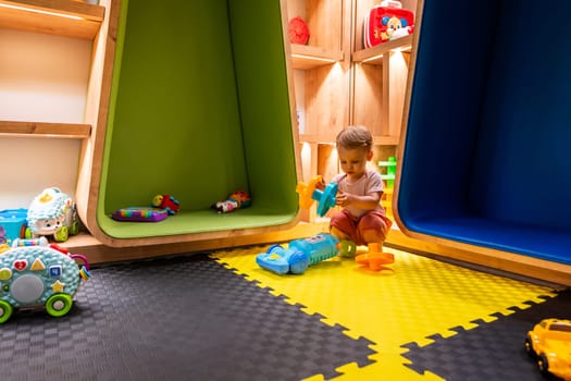 Toddler playing with toys in a colorful and modern playroom designed for learning and creativity