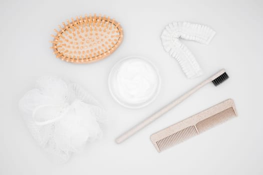 Natural bath accessories. Wooden hairbrush, cream, toothbrush, comb, loofah, hair ties.