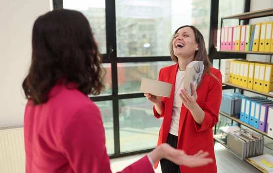 Two coworkers engaged in a professional office discussion.