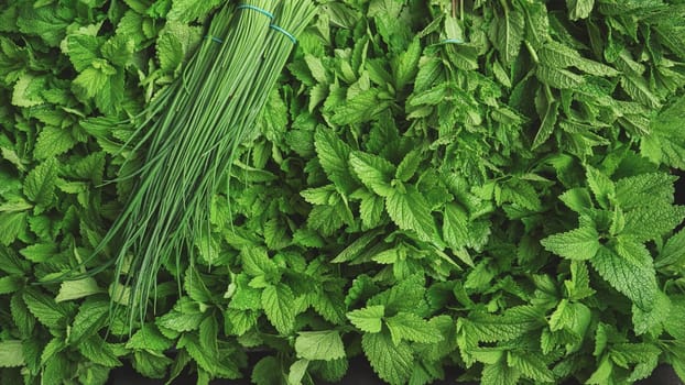 Fresh mint leaves and bunch of chives on display at herbs market