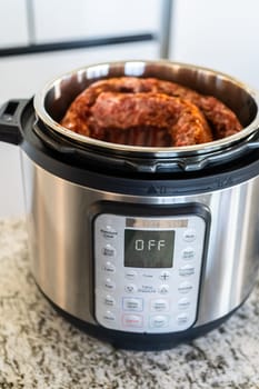 In a sleek modern kitchen, were adding an extra layer of flavor to succulent baby back ribs by infusing them with a medley of spices in a multicooker-a mouthwatering feast in the making.