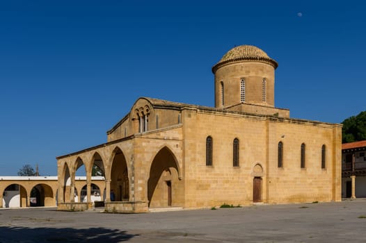 Ancient stones of a beautifully crafted church bask in sunlight, surrounded by quiet village life and a vibrant history.