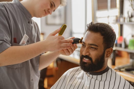 In a stylish and contemporary salon environment, a skilled barber expertly trims the hair of a satisfied client