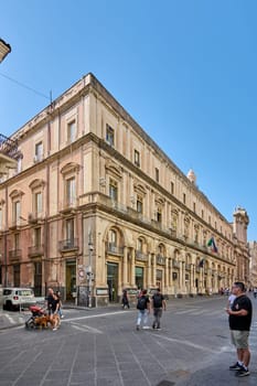 Catania. Italy - February 27, 2025: The majestic Palazzo Minoriti stands tall in Catania, showcasing its classic architecture. Ideal for travel blogs, architectural studies, and urban lifestyle shoots