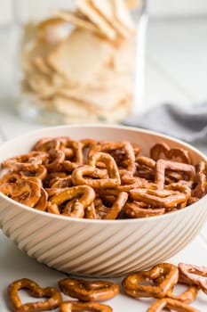 Heart shaped pretzel in bowl  on a white table.