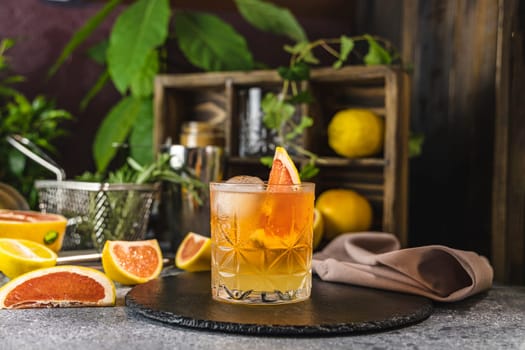 Vibrant paloma cocktail, adorned with a grapefruit slice, sits on a slate coaster, embodying summer refreshment