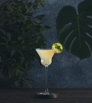 Refreshing tropical cocktail served in an elegant glass, garnished with lime wheel and mint leaves, placed on a dark wooden table