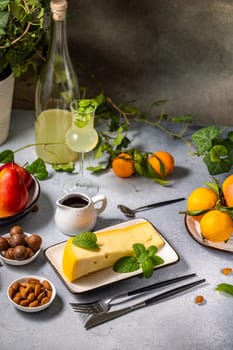 Sophisticated arrangement featuring gourmet cheese, fresh mint, vibrant fruits, assorted nuts, and a glass of limoncello