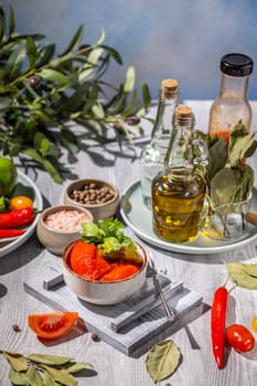 Delicious red peppers are waiting to be tasted, accompanied by fresh herbs, spices, and high-quality olive oil