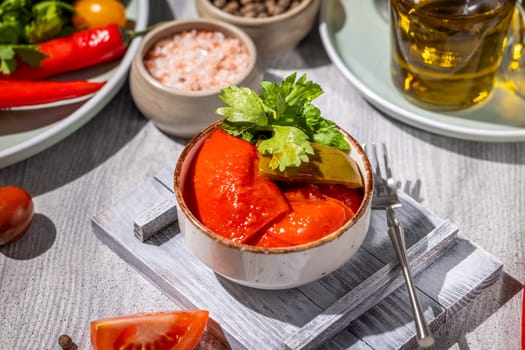 Pickled tomatoes and peppers seasoned with herbs and spices served in a rustic bowl, showcasing the flavors of preserved vegetables
