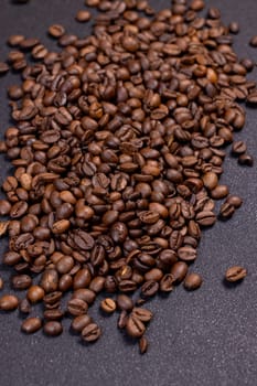 Roasted coffee beans forming a pile on a dark background, creating a visually appealing image for coffee lovers