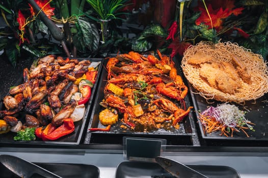 hot dishes garnish at Asian buffet in restaurant in hotel for breakfast. Fried chicken meat and crayfish at the Asian night market in Vietnam