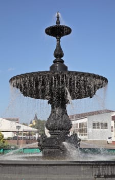 A stunning black fountain stands tall in Nizhny Novgorod, with water cascading beautifully on a clear day.