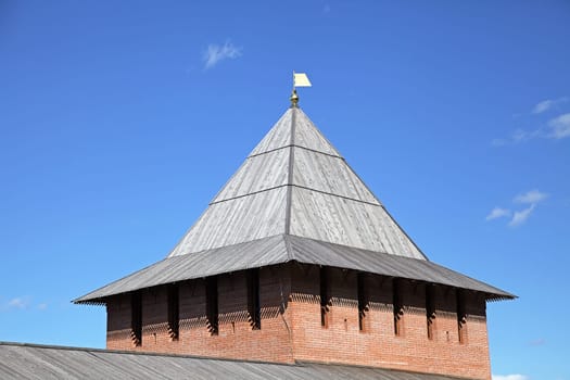 The wooden roof of a historic tower in Nizhny Novgorod kremlin is beautifully illuminated under the bright sky.