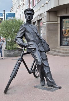 Nizhny Novgorod, Russia - August 27, 2016 - A detailed bronze sculpture depicts a bicycle messenger