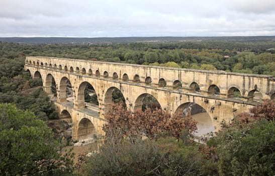 The magnificent Pont du Gard stretches across a lush landscape in France.