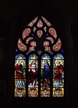 Stained glass window with vibrant colors and religious figures in Toulouse's Cathedral Saint-Etienne.
