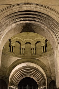 Historic Toulouse structure boasts intricate arches and columns, beautifully lit at night for a captivating view.