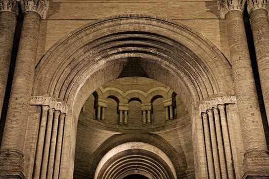 Historic Toulouse structure boasts intricate arches and columns, beautifully lit at night for a captivating view.