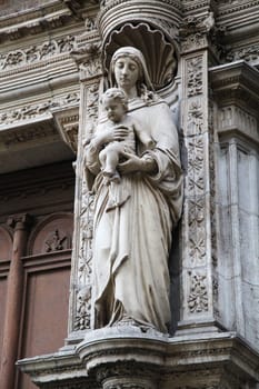 The sculpture showcases the Virgin Mary holding a child, displaying exquisite detail on a Toulouse building.
