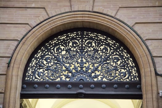 Ornate ironwork adorns an archway in Toulouse, highlighting the city's rich architectural heritage.