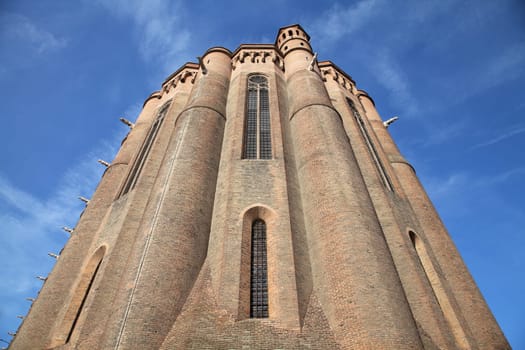 Sainte-Secile cathedral in Albi stands tall with its intricate brickwork and majestic towers against a vibrant sky.