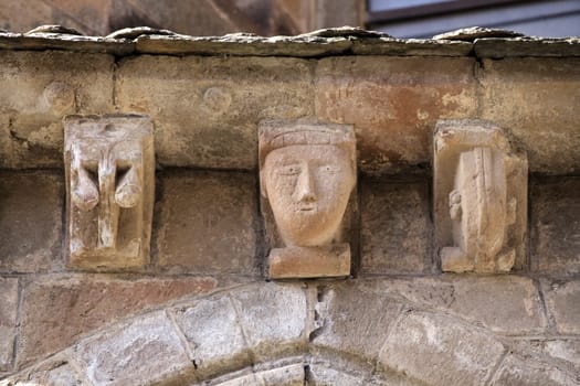 Intricate stone carvings decorate the exterior of an ancient structure in Conques, revealing the artistry of the era.