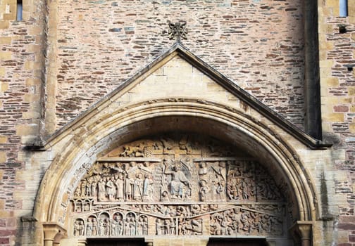 Detailed stone sculptures at the church entrance in Conques highlight medieval craftsmanship and artistic expression.