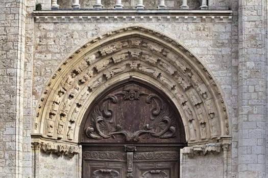 Close-up view of ornate stone arch and wooden door showcasing exceptional craftsmanship in Blois, France.
