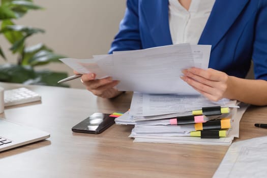 An accountant analyzes tax documents while seated at a desk, preparing for IRS filing with organized paperwork.