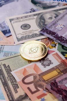 Round metal ethereum on a background of paper banknotes of different currencies. Background for your design