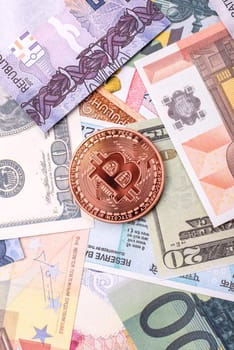 Round metal bitcoin on a background of paper banknotes of different currencies. Background for your design