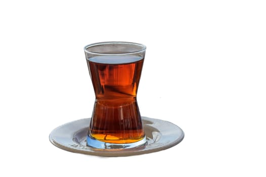 A beautifully crafted glass holds aromatic tea, resting on an elegant dish, inviting relaxation and warmth.